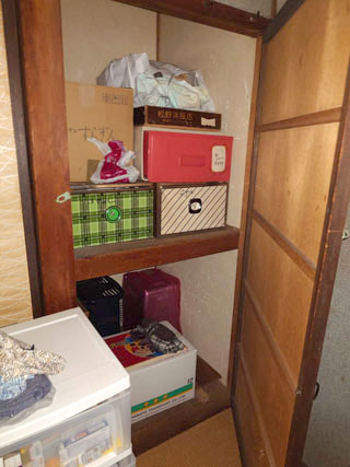 衣類や箱が残った押入れ